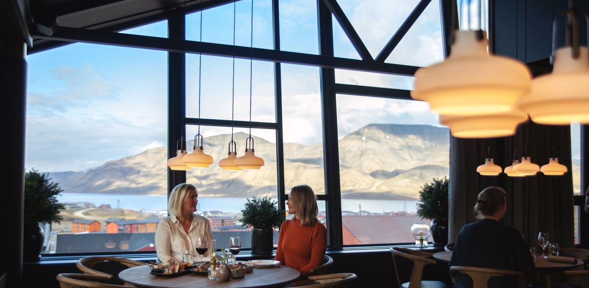 to kvinder i restauranten med udsigt til hvidklædte bjerge