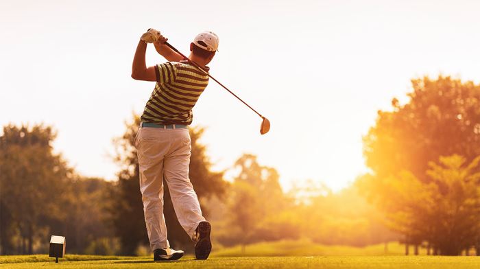 Golf spiller spiller i solnedgange