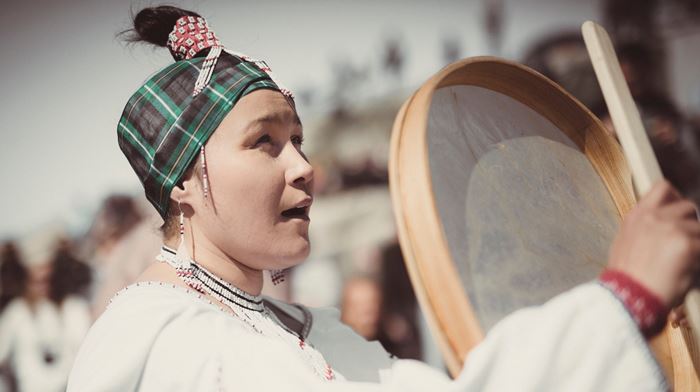 Grønlandske nationaldag fejres af kvinde med trommedans og iklædt nationaldragt