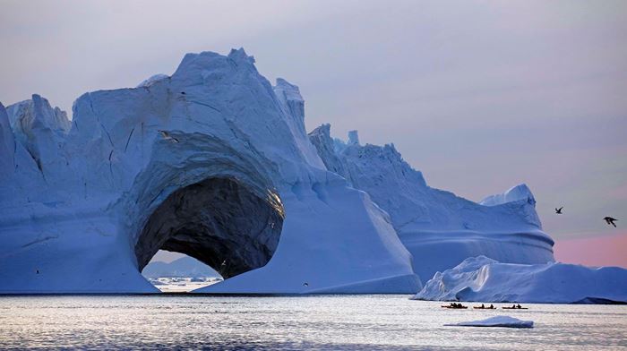 Små kajakker på tur mellem kæmpe isbjergsformation