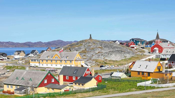 Udsigt over farverige tage i Nuuk med forden og bjerge i baggrunden