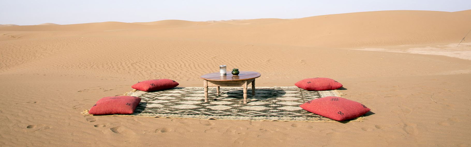 Marokko Vejr Billede, opstilling med tæppe, puder og bord i ørkenlandskab