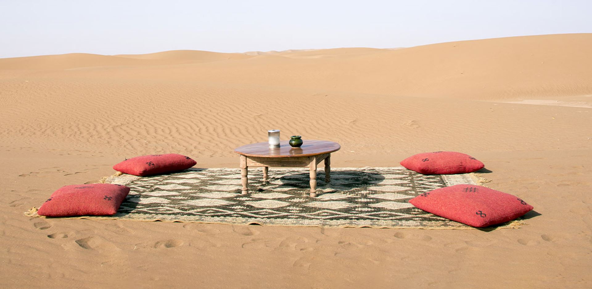 Marokko Vejr Billede, opstilling med tæppe, puder og bord i ørkenlandskab