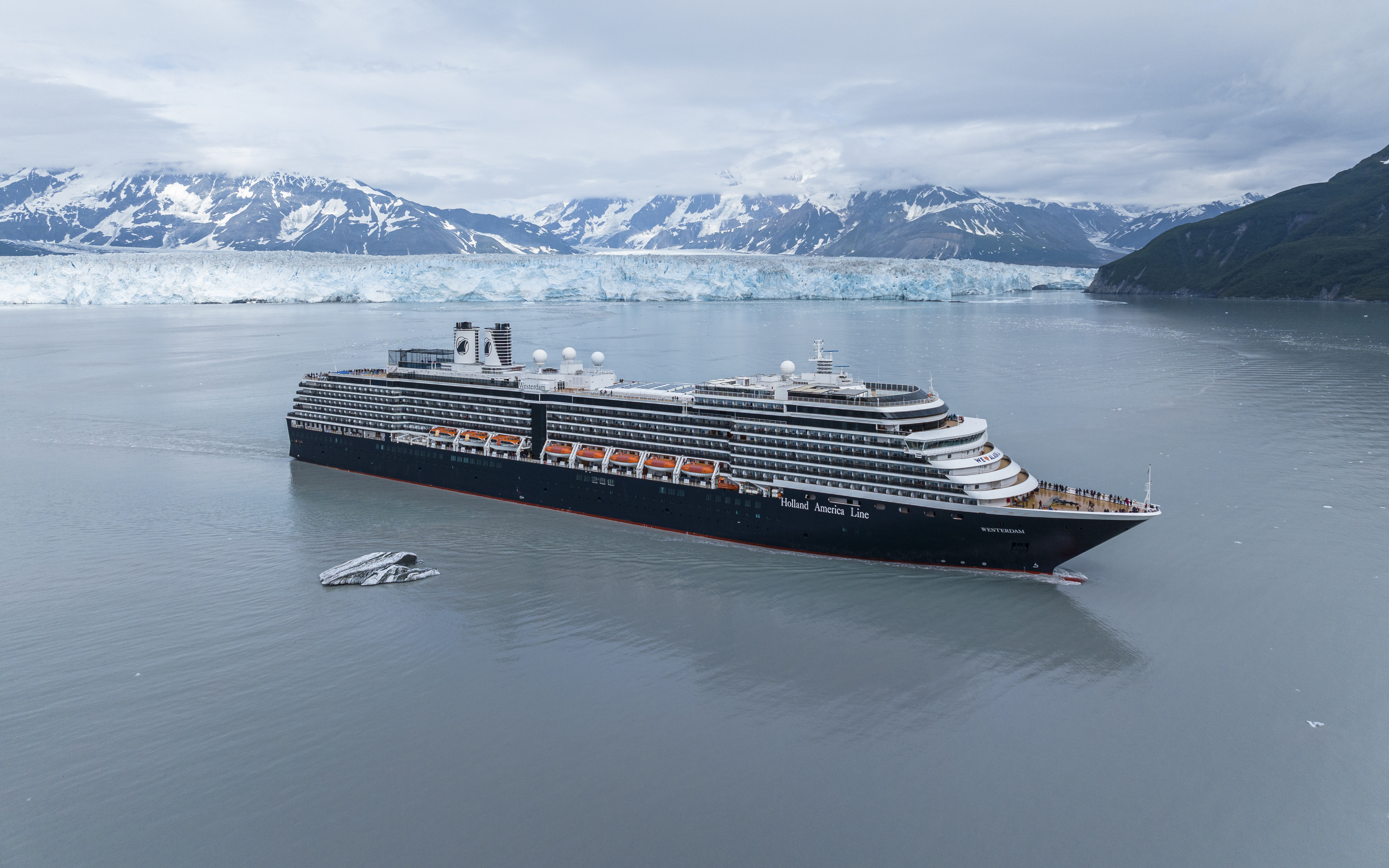 MS Westerdam krydstogtskib foran Hubbard Glacier i Alaska omgivet af isfyldt vand og sneklædte bjerge