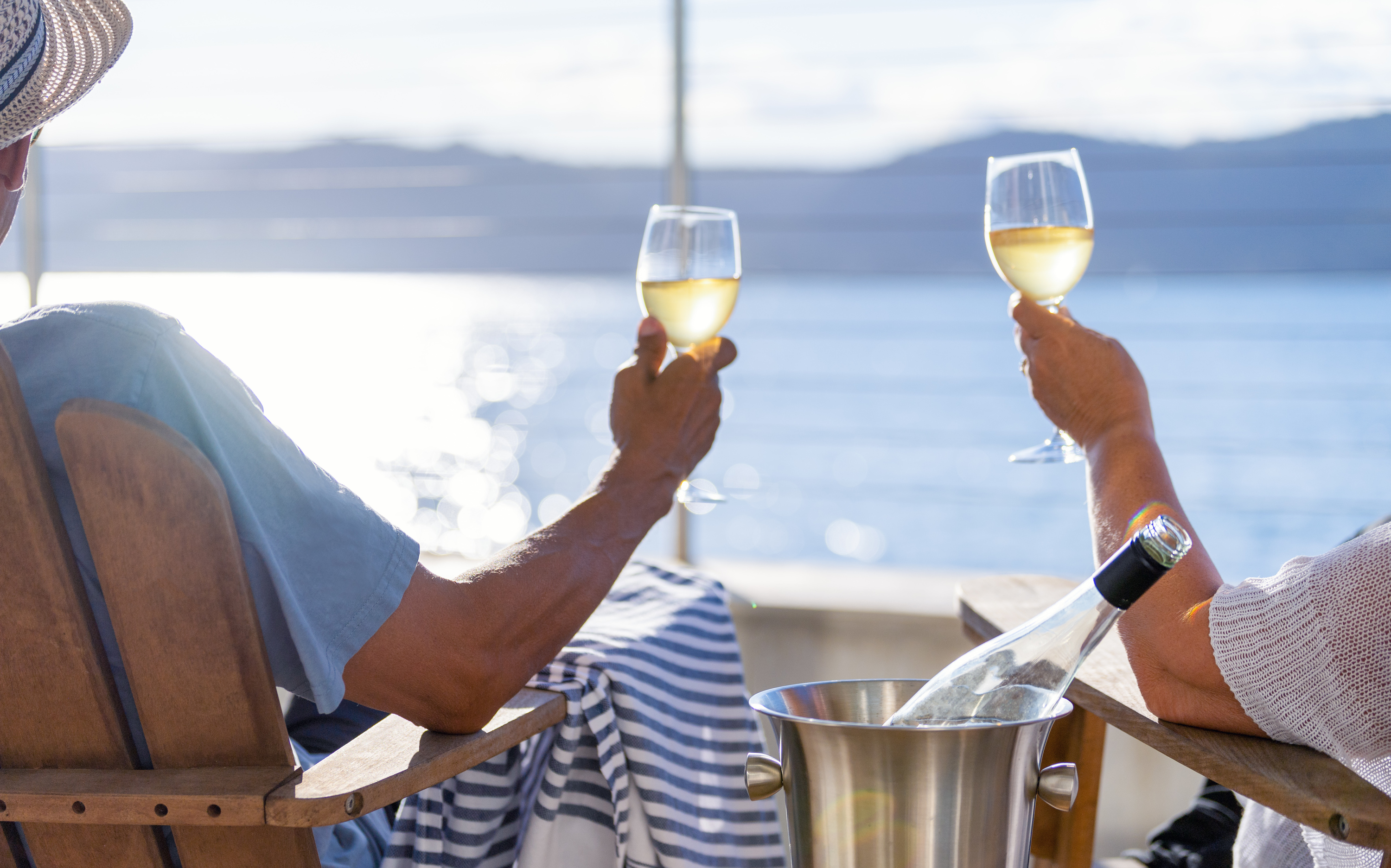 Par nyder champagne i liggestole på dækket med havudsigt ombord på Holland America Line krydstogt