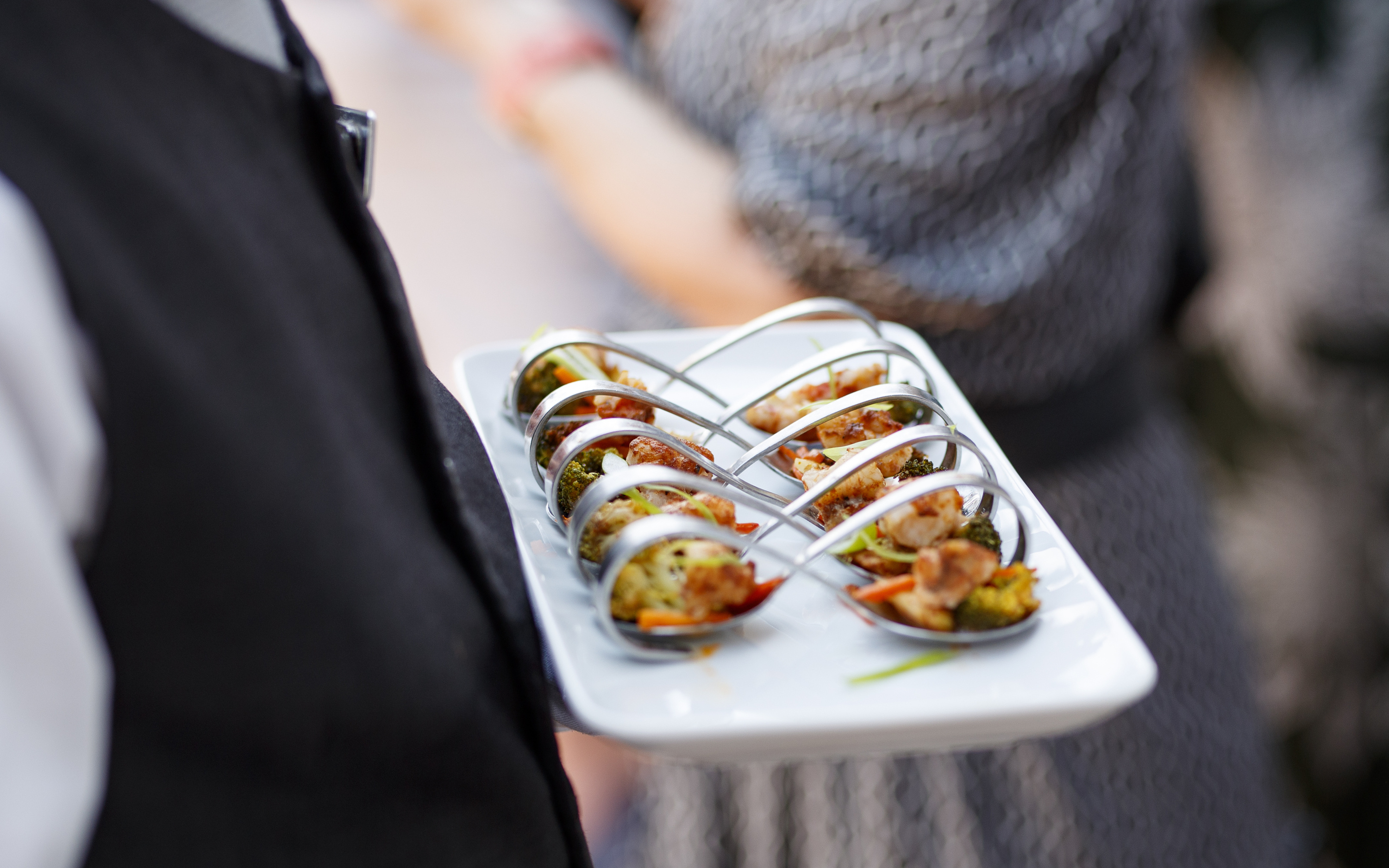 Tjener bærer fad med elegante gourmet-forretter til gæster ombord på et Holland America Line krydstogtskib