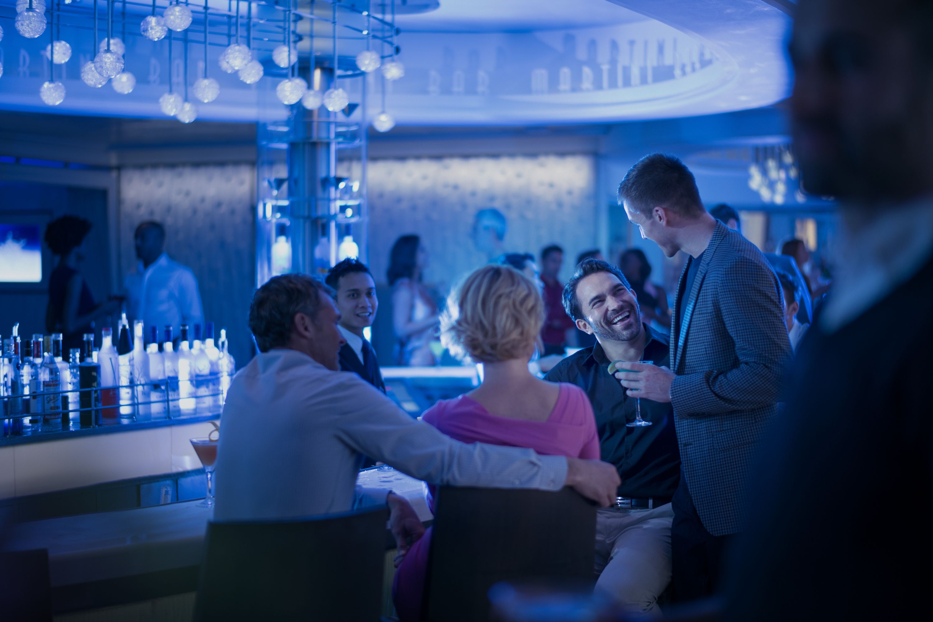 Martini Bar Crush på Celebrity Equinox – Moderne bar med blå stemningsbelysning, krystalophæng og livlig social atmosfære