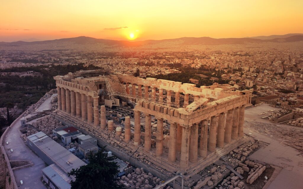 Akropolis og Parthenon i Athen set fra luften i solnedgang med storbyen bredt ud omkring