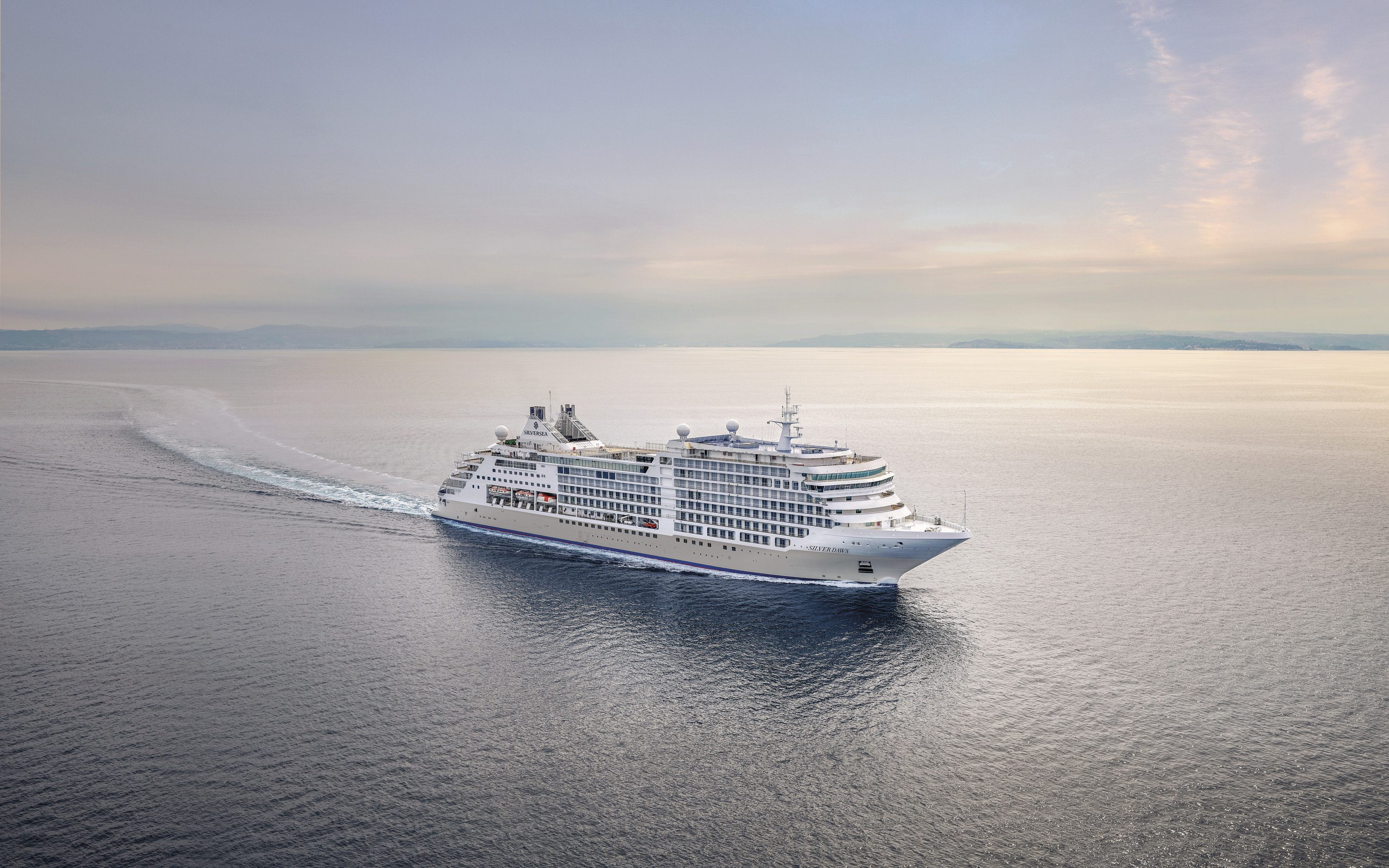 Luksuriøst Silversea-krydstogtskib sejler gennem roligt hav i blød aftensol