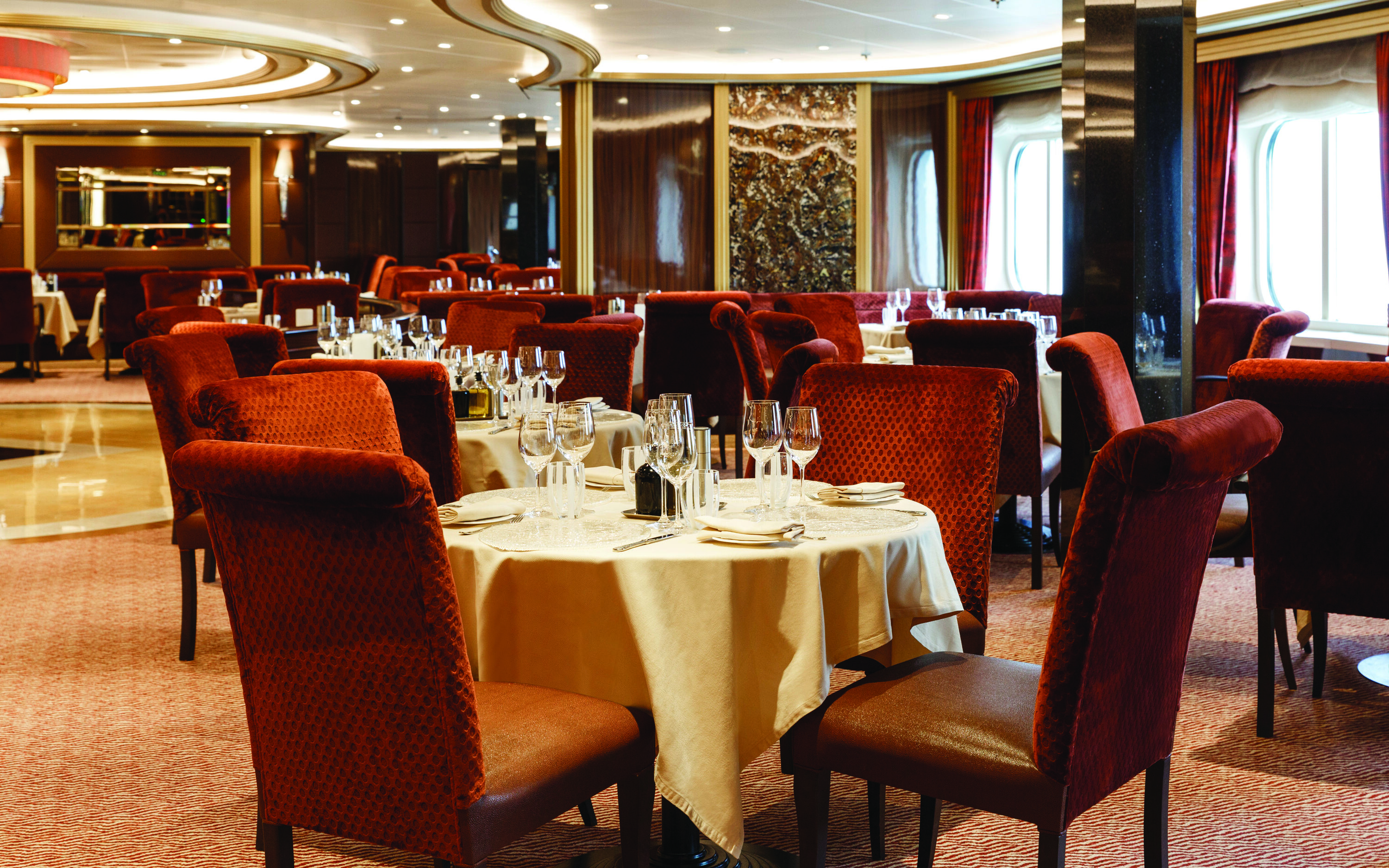 Atlantide hovedrestaurant på Silver Spirit med opdækkede borde og røde stole