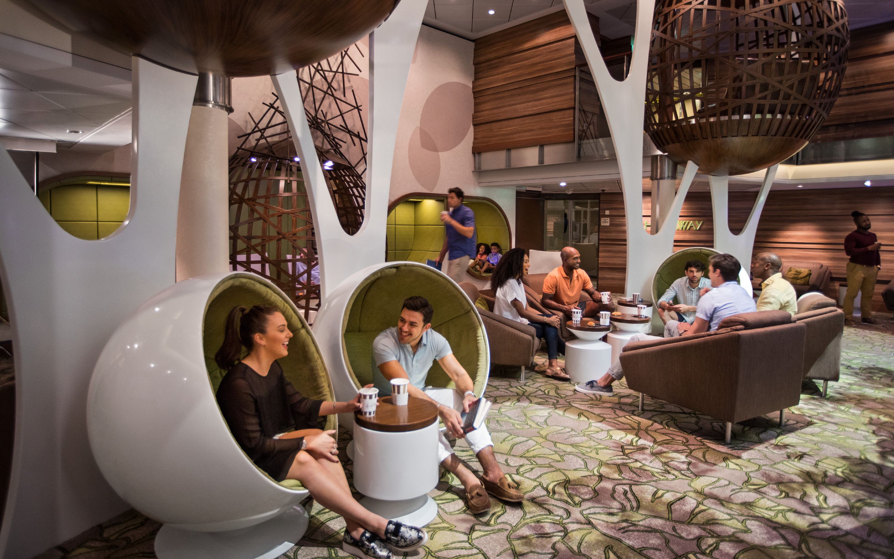 The Hideaway på Celebrity Cruises – Moderne loungeområde med innovative hvide pod-siddepladser og stilrent design med træelementer