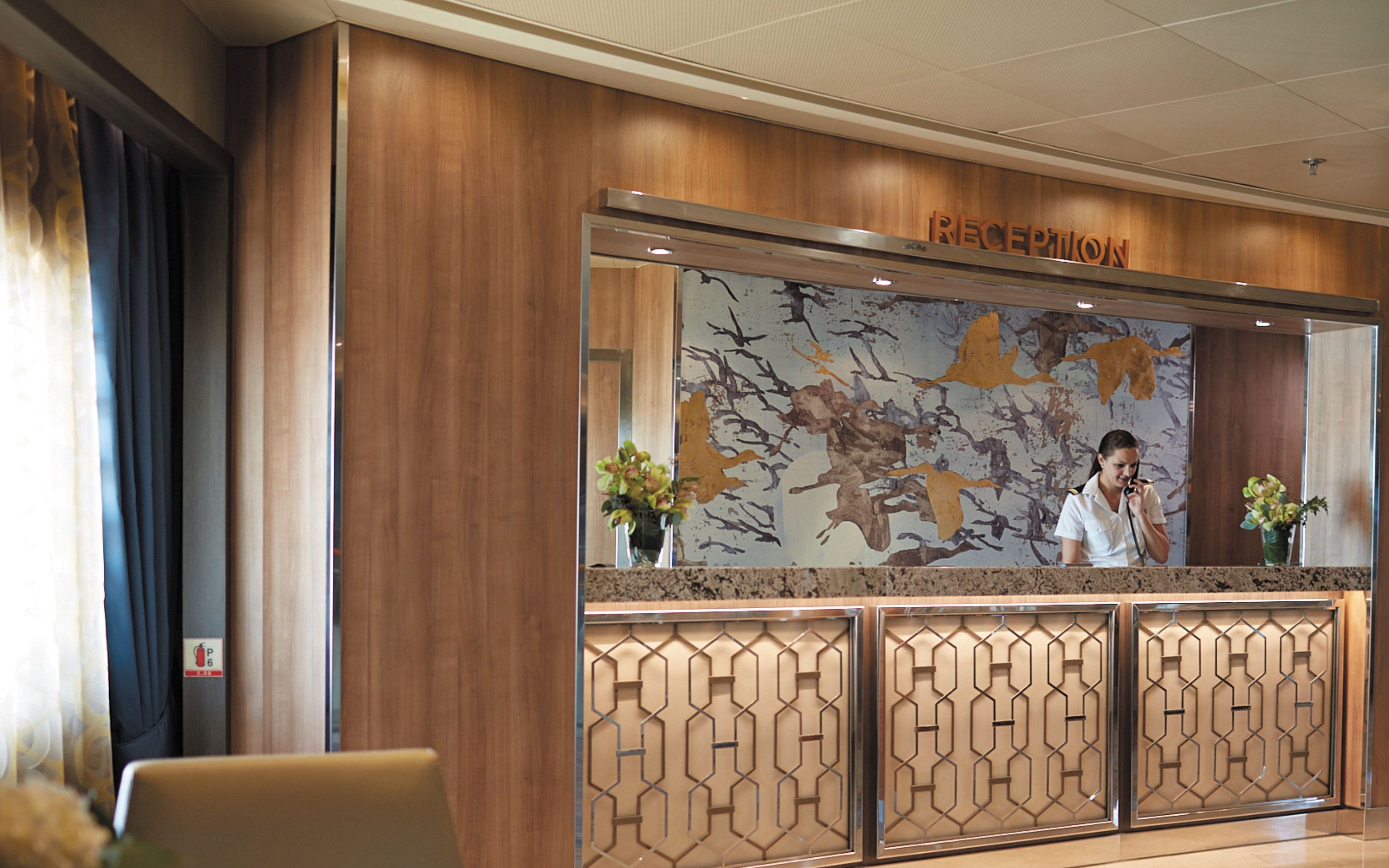 Receptionen ombord på Seven Seas Voyager med bemandet skranke og elegant kunstvæg