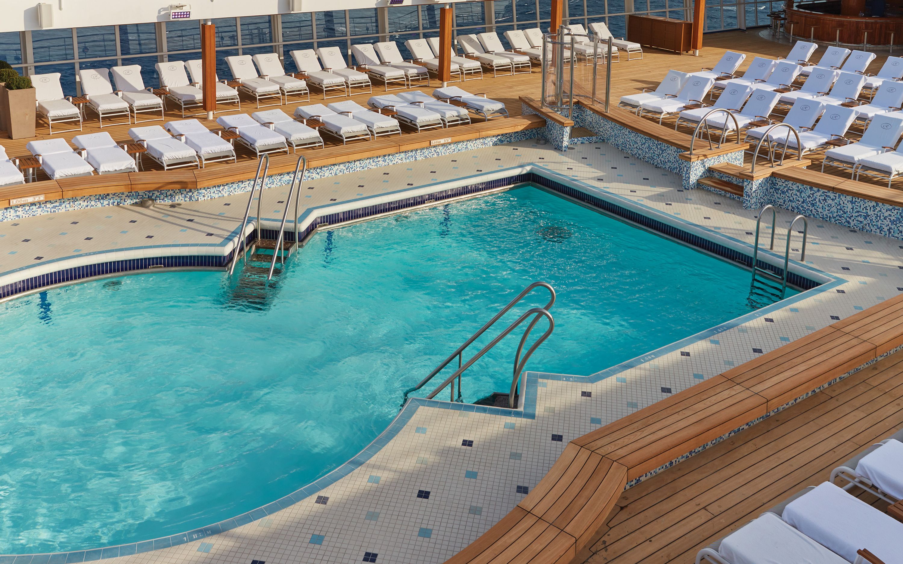 Poolområde på Seven Seas Voyager med mange liggestole og flisebelagt swimmingpool