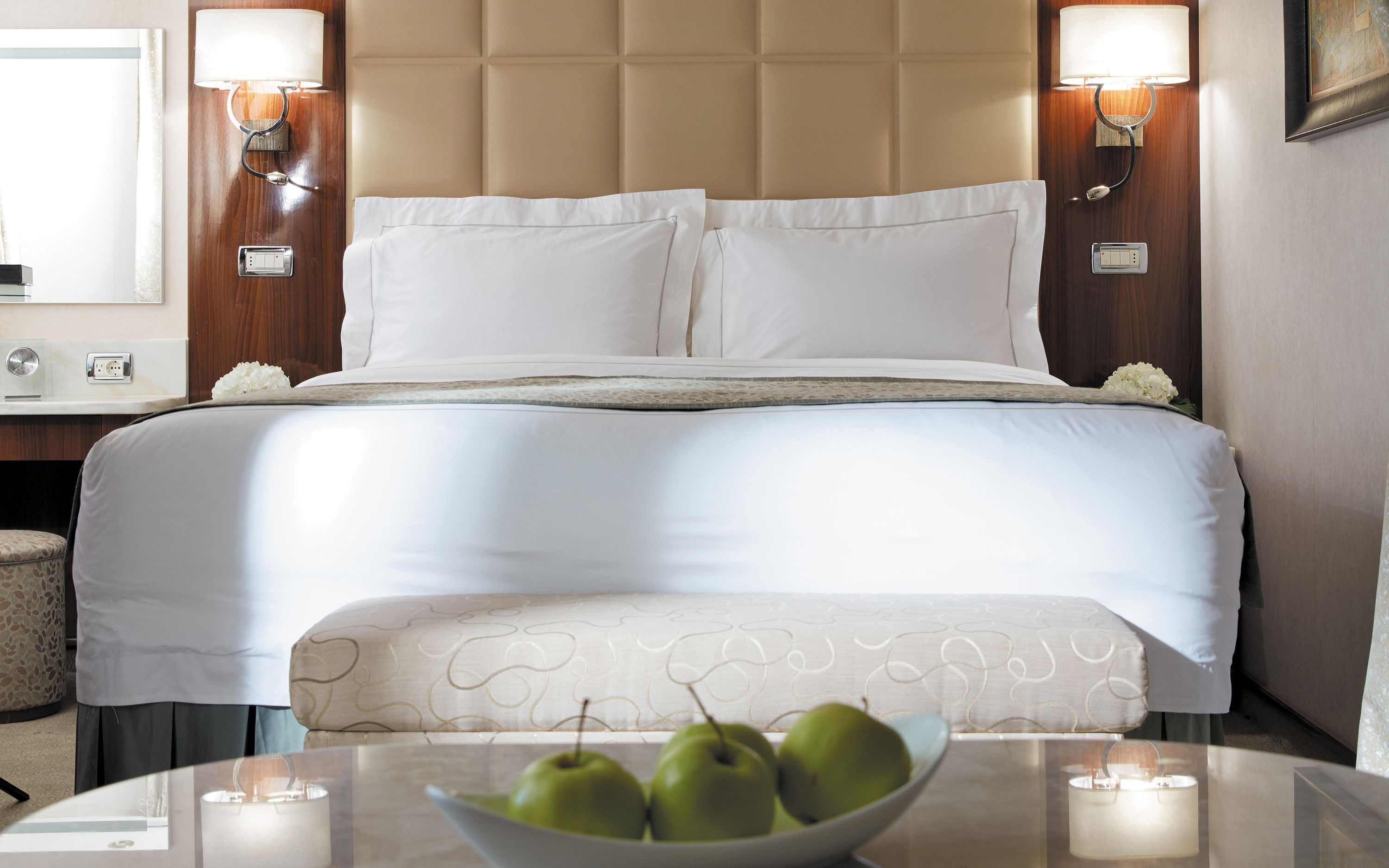 Komfortabel dobbeltseng i lys suite på Seven Seas Voyager med moderne indretning